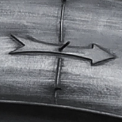 The rolling direction of the tyre is denoted by an arrow on one side of the sidewall